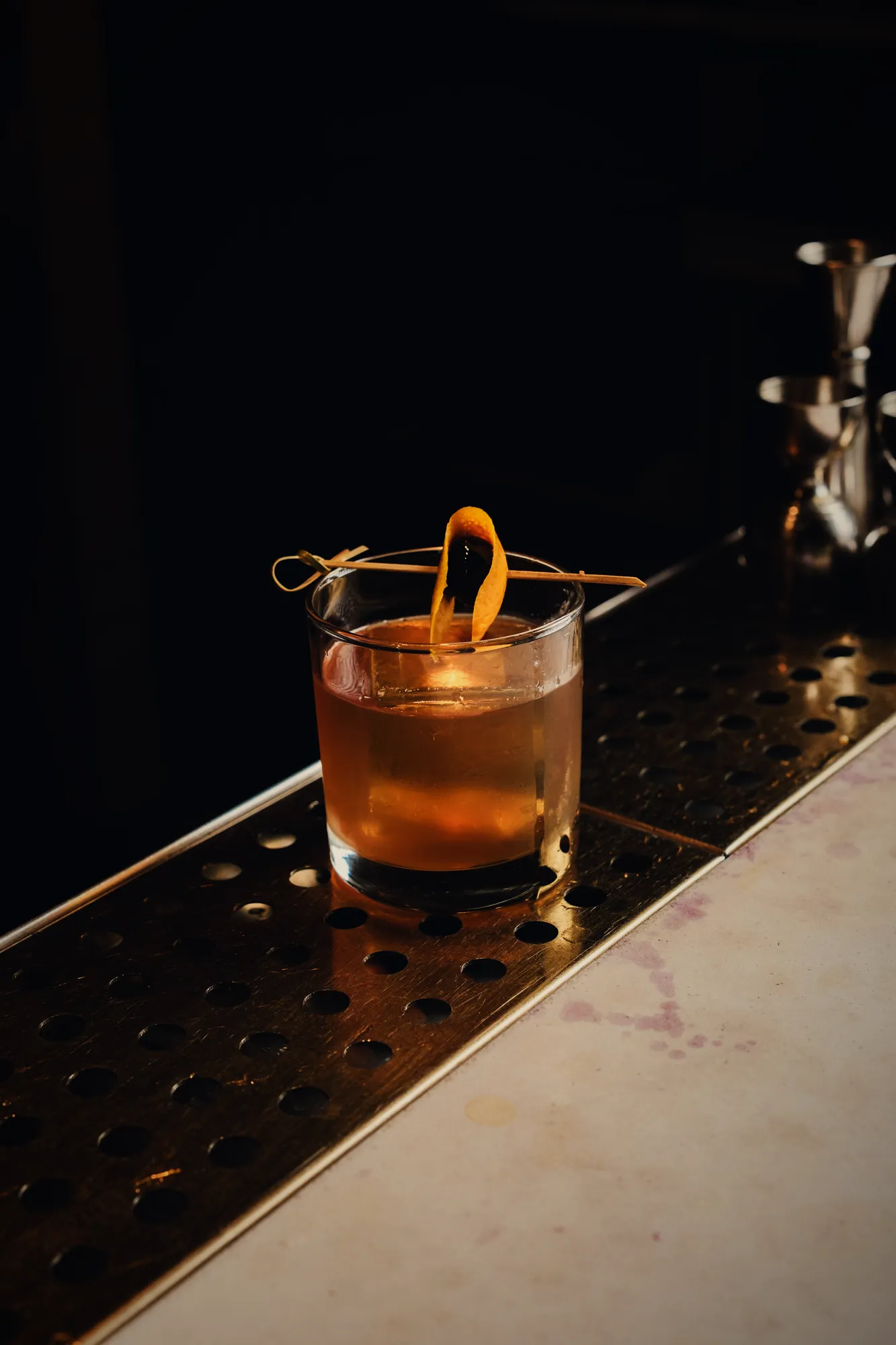 Old fashioned with orange twist on the bar counter